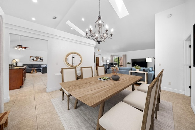 tiled dining room featuring ceiling fan with notable chandelier, a skylight, high vaulted ceiling, and sink