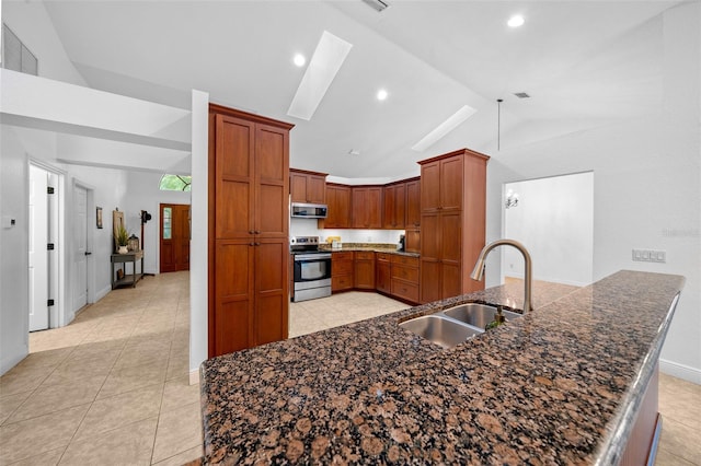 kitchen with sink, light tile patterned flooring, lofted ceiling, and appliances with stainless steel finishes