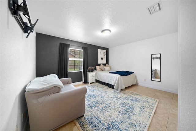 bedroom with light tile patterned flooring and a textured ceiling