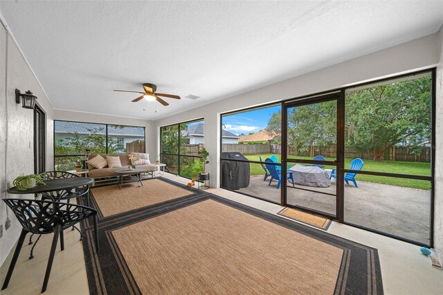 unfurnished sunroom featuring ceiling fan