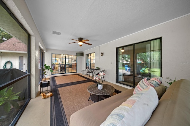 living room featuring a textured ceiling, plenty of natural light, and ceiling fan