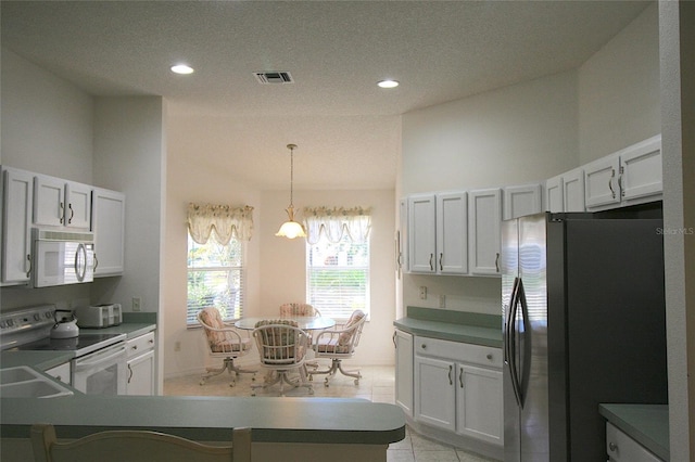 kitchen featuring a textured ceiling, white cabinets, pendant lighting, and white appliances