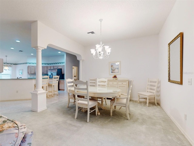 dining space featuring light carpet, a textured ceiling, and a notable chandelier