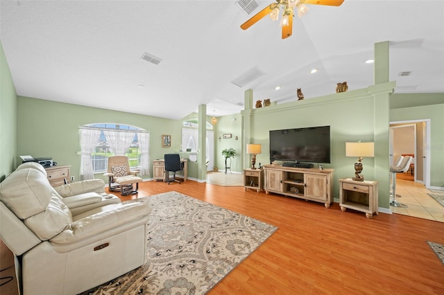 living room with vaulted ceiling, ceiling fan, and light hardwood / wood-style floors