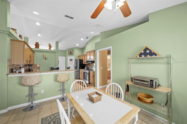 tiled dining space with lofted ceiling and ceiling fan