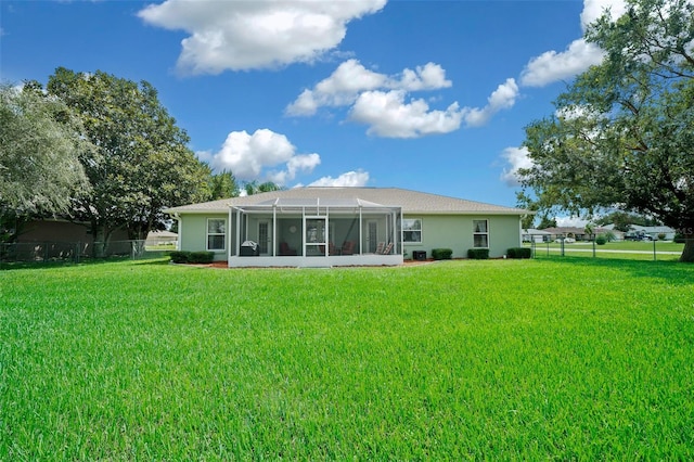 back of property with a yard and a sunroom