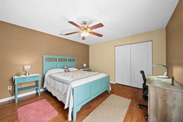 bedroom featuring dark hardwood / wood-style flooring, ceiling fan, and a closet