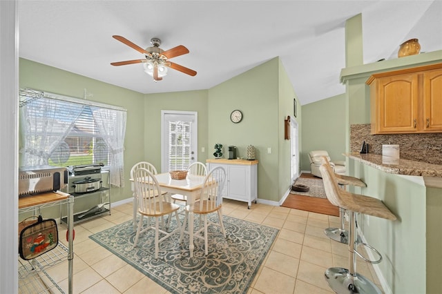 tiled dining room with lofted ceiling and ceiling fan