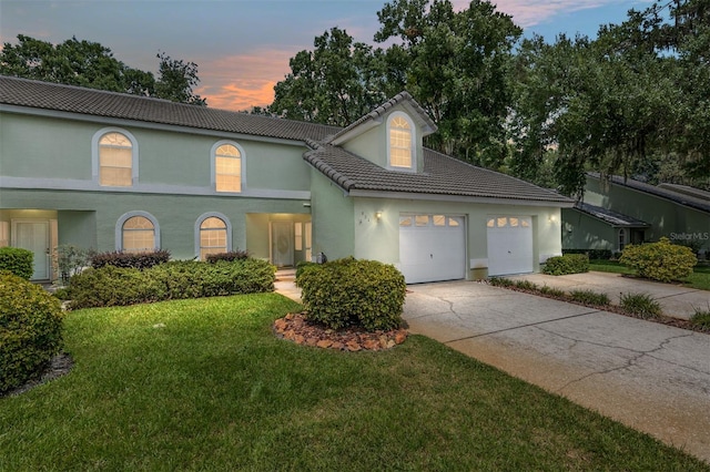 view of front of house with a garage and a lawn