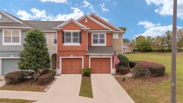 townhome / multi-family property with a garage and a front yard