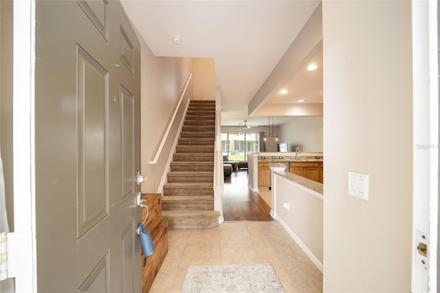 staircase with ceiling fan and tile patterned floors