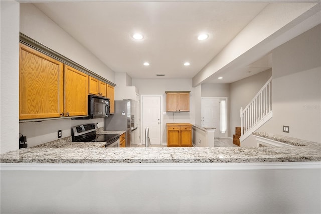 kitchen featuring stainless steel appliances, sink, light stone countertops, and kitchen peninsula