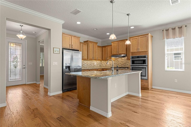 kitchen with decorative backsplash, ornamental molding, a textured ceiling, an island with sink, and stainless steel appliances