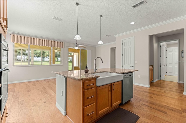 kitchen featuring ceiling fan, sink, stainless steel appliances, a textured ceiling, and a kitchen island with sink