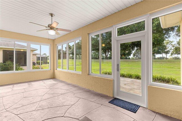 unfurnished sunroom featuring ceiling fan