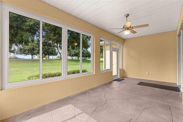 unfurnished sunroom with ceiling fan