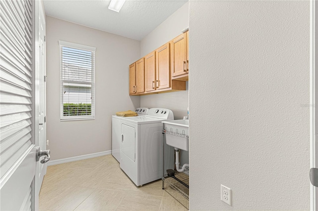 laundry area featuring cabinet space, baseboards, a textured ceiling, and independent washer and dryer