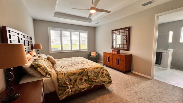 carpeted bedroom with ceiling fan and a tray ceiling