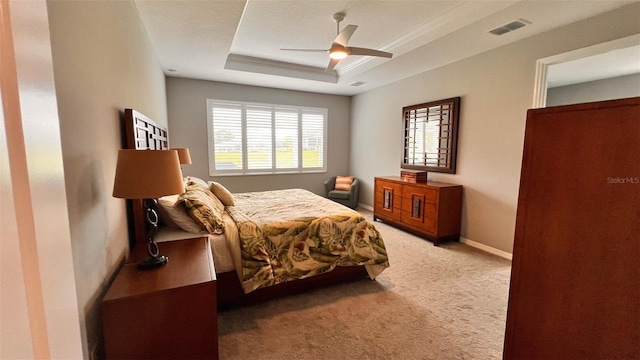 bedroom featuring a raised ceiling, ceiling fan, and carpet flooring