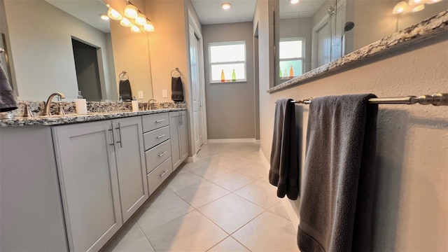 bathroom featuring vanity, a shower with shower door, and tile patterned floors