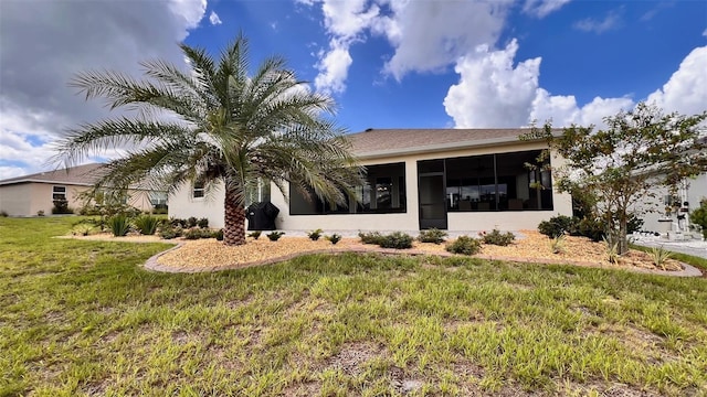 view of front of house with a front yard and a sunroom