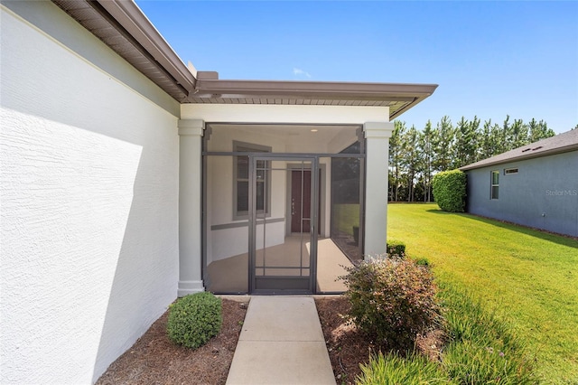 entrance to property featuring a lawn