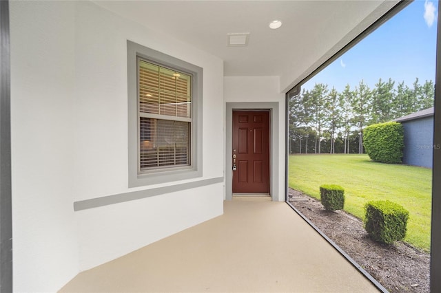 property entrance featuring a lawn