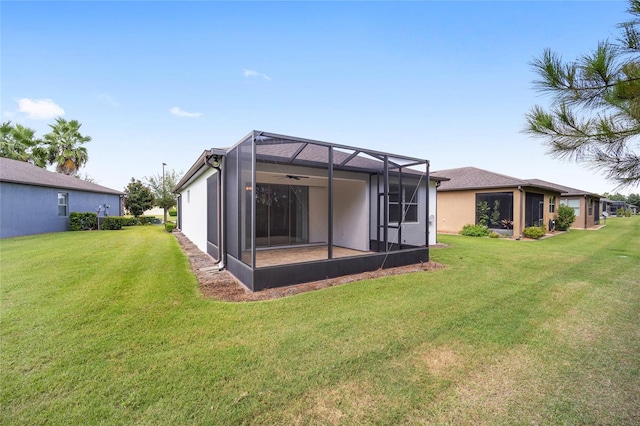 rear view of property featuring a lanai and a lawn