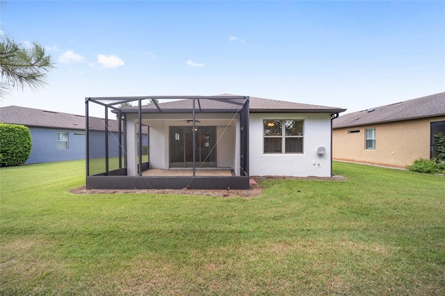 rear view of property featuring a lanai and a lawn