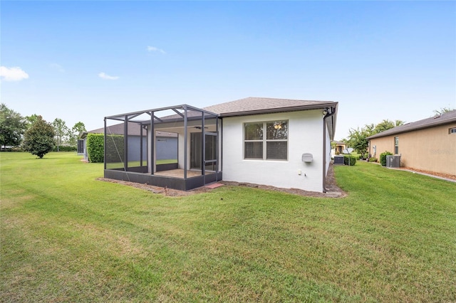 back of house with a yard, a lanai, and central AC