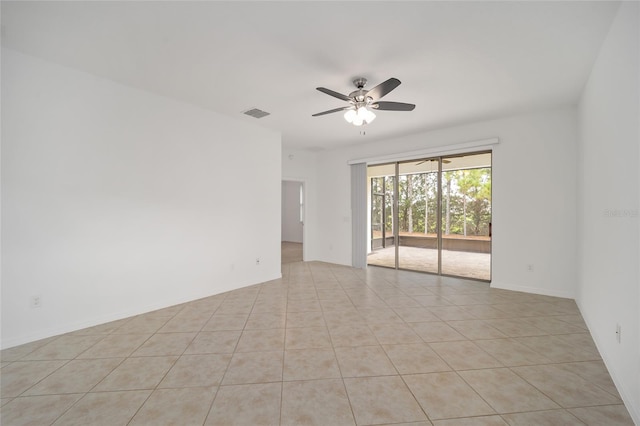 tiled spare room featuring ceiling fan