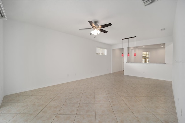 unfurnished living room with ceiling fan, plenty of natural light, and light tile patterned flooring