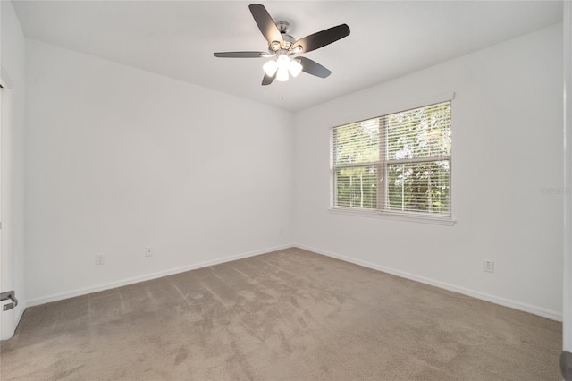 empty room featuring ceiling fan and light colored carpet