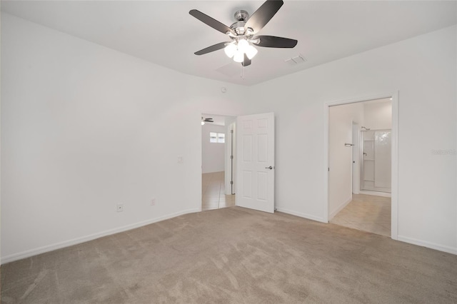 unfurnished bedroom featuring ceiling fan, light colored carpet, and ensuite bathroom