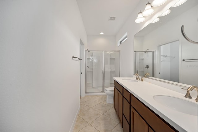 bathroom with tile patterned flooring, vanity, toilet, and a shower with shower door