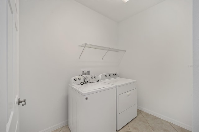 laundry room with washing machine and dryer and light tile patterned floors