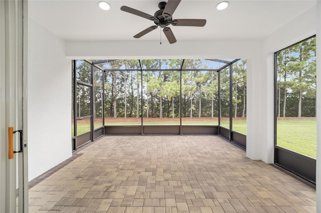 unfurnished sunroom featuring ceiling fan