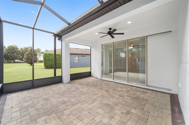 unfurnished sunroom featuring ceiling fan