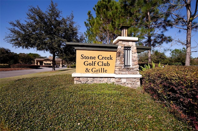 community / neighborhood sign featuring a lawn