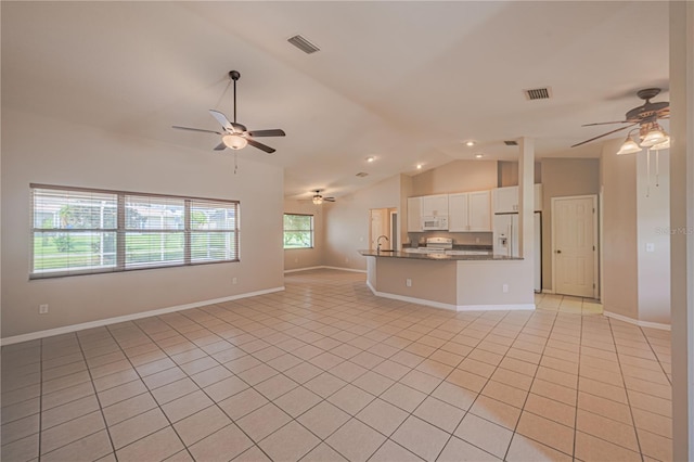 unfurnished living room with vaulted ceiling, light tile patterned floors, and ceiling fan