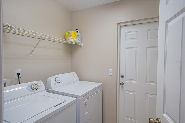 clothes washing area with washing machine and dryer