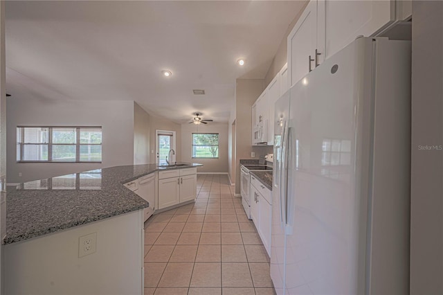 kitchen featuring dark stone countertops, white cabinetry, white appliances, light tile patterned floors, and ceiling fan