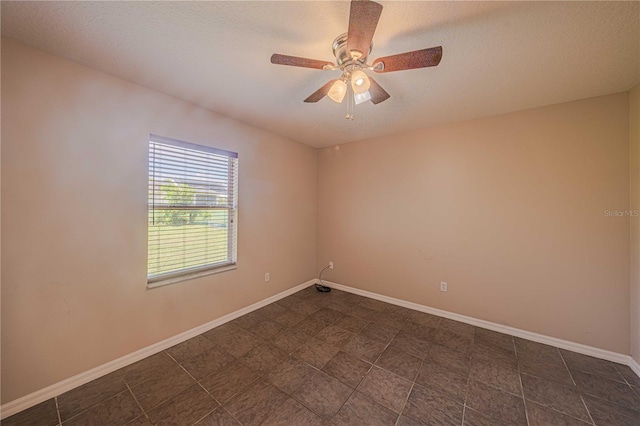 unfurnished room with a textured ceiling, a ceiling fan, and baseboards