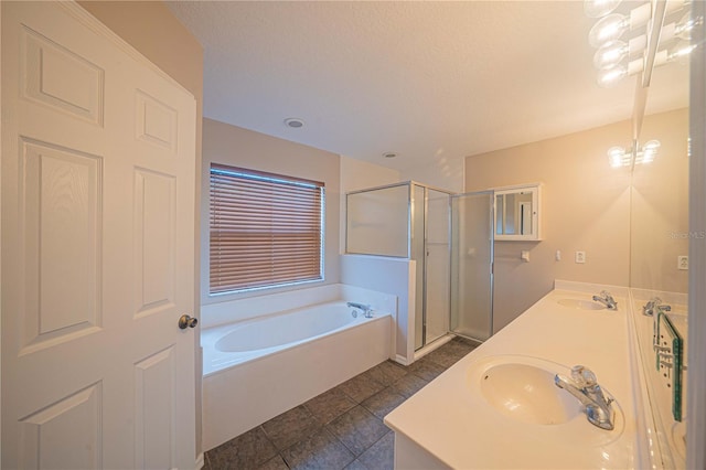 bathroom featuring a stall shower, double vanity, a sink, and a bath