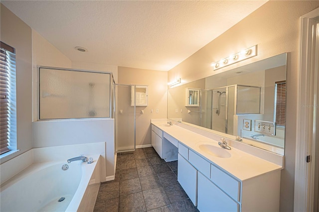 full bath with double vanity, a sink, a textured ceiling, a shower stall, and a bath