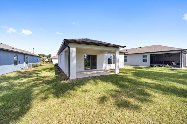 rear view of property featuring a lawn, a patio, and cooling unit