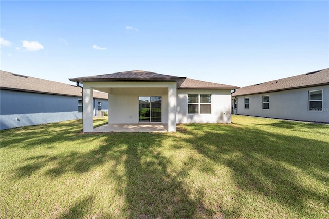 rear view of house with a lawn and a patio area