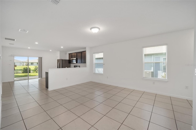 unfurnished living room with a wealth of natural light and light tile patterned floors