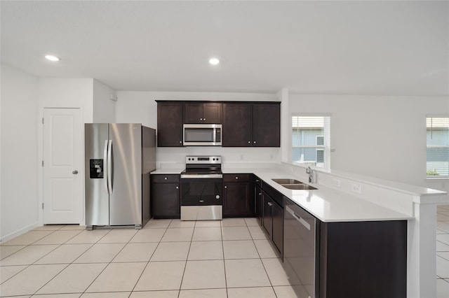 kitchen with light tile patterned floors, stainless steel appliances, plenty of natural light, and sink