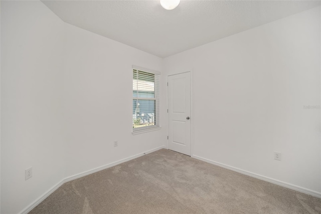 unfurnished room featuring light carpet